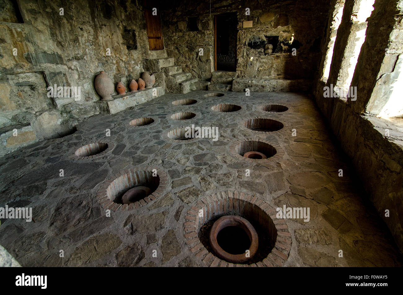 Antica sala di fermentazione con vasi di argilla in una struttura in pietra di civiltà storica Foto Stock