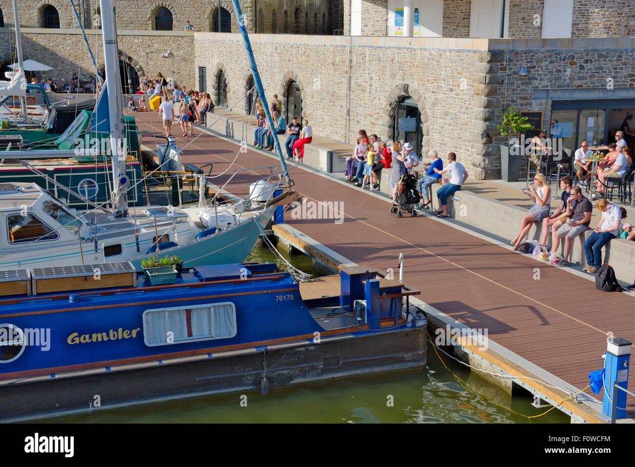 Persone sedute e barche in Bristol Floating Harbour al fine di millennio Promenade Foto Stock