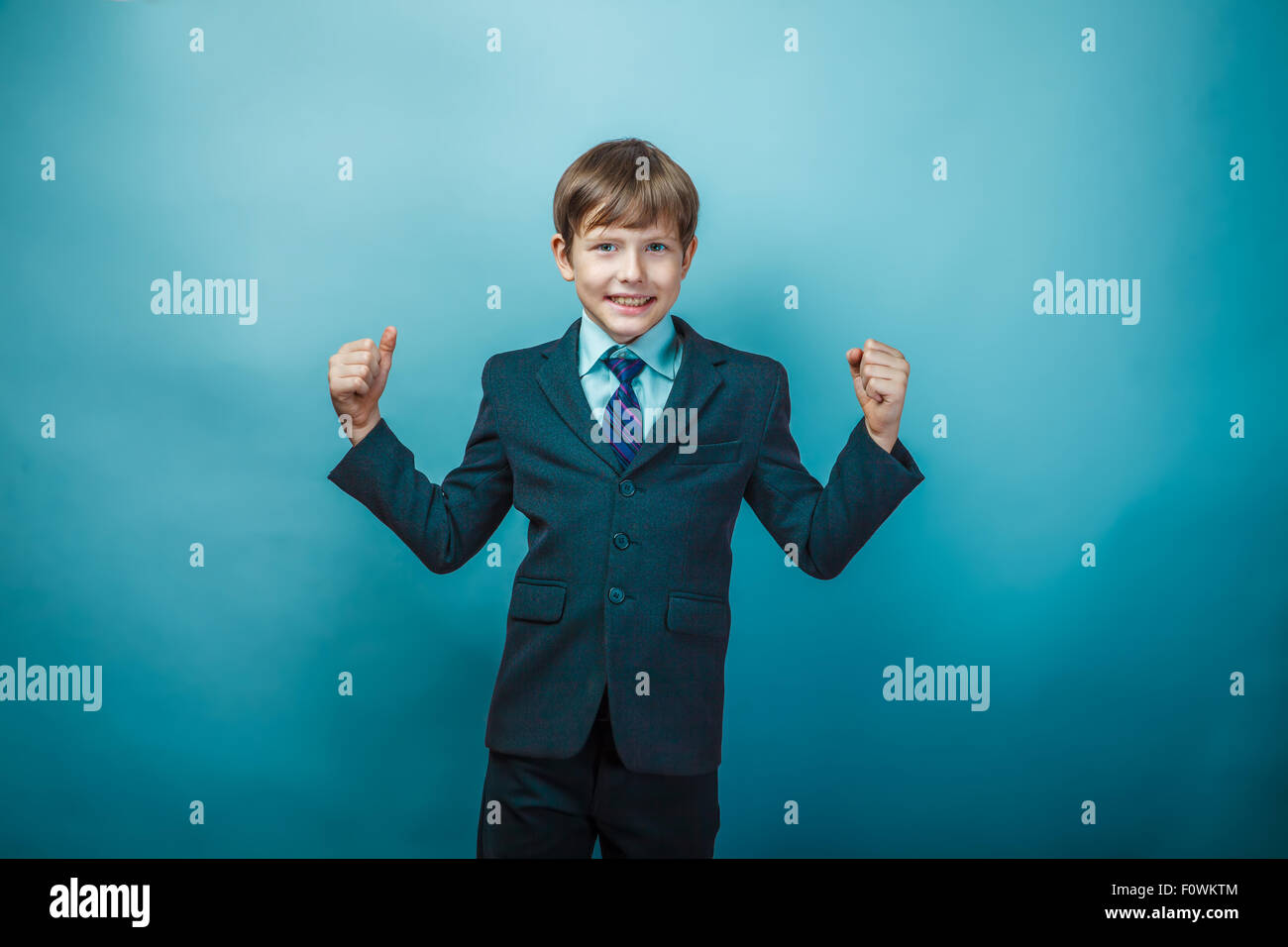 Teen boy proprietari in un vestito di gioia il successo gesti con le mani ra Foto Stock