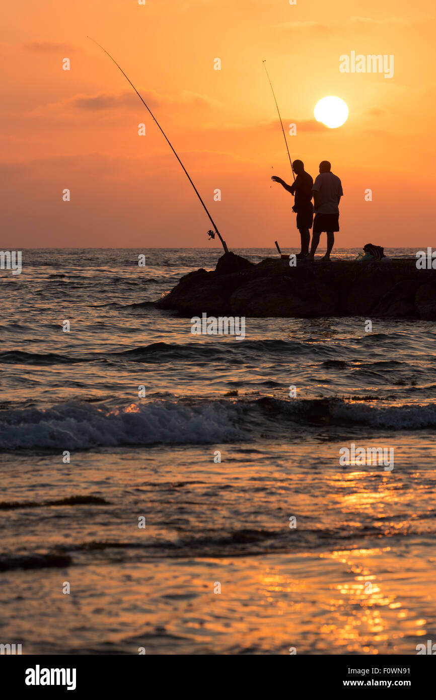 Due pescatori al tramonto a Paphos in Cipro Foto Stock