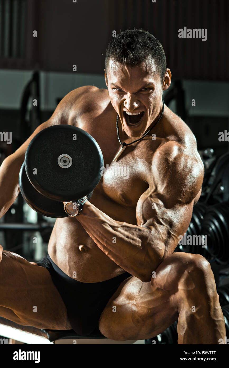 Molto potere athletic guy , eseguire esercizi con pesi, su sfondo bkack Foto Stock