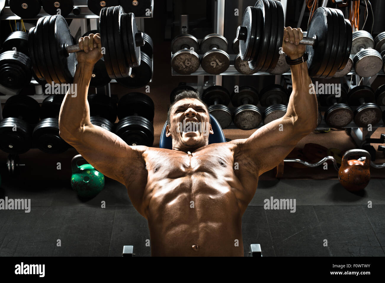 Molto potere athletic guy bodybuilder , eseguire esercizio premere dei pesi sul muscolo pettorale, in palestra Foto Stock