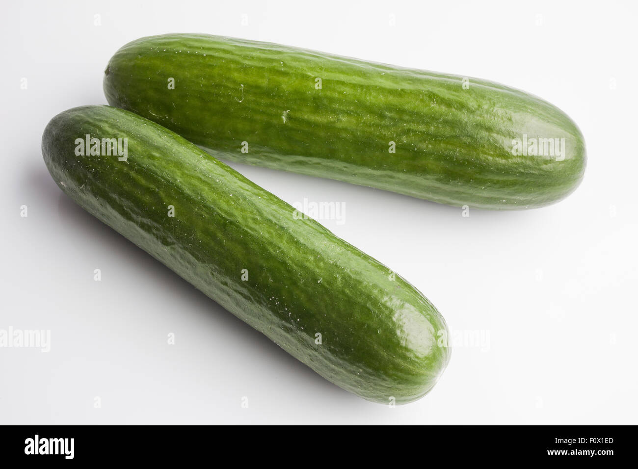 Due interi grandi cetrioli su sfondo bianco Foto Stock