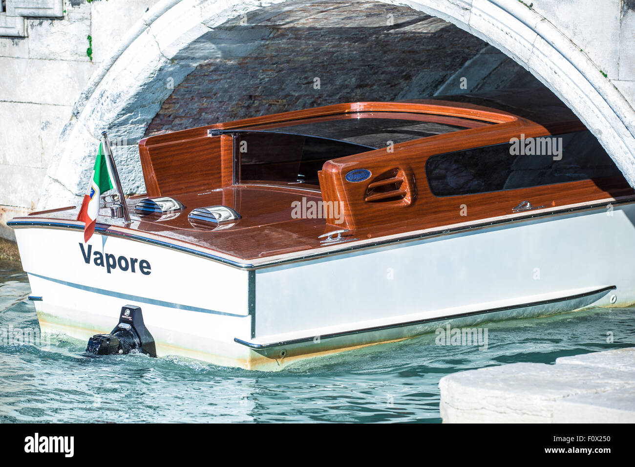 A Venezia il taxi acqueo si inverte sotto un ponte sul canale Foto Stock