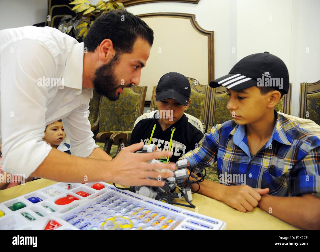 Damasco, Siria. Il 22 agosto, 2015. Siro orfani a frequentare un corso di formazione sulla progettazione di semplici progetti elettronici in un campo estivo in Damasco Capitale della Siria, su agosto 22, 2015. Il corso è stato tenuto dal governo siriano in cooperazione con le associazioni di beneficenza locali per aiutare a sviluppare le competenze dei bambini che hanno perso i loro genitori durante il conflitto in Siria. © Ammar/Xinhua/Alamy Live News Foto Stock