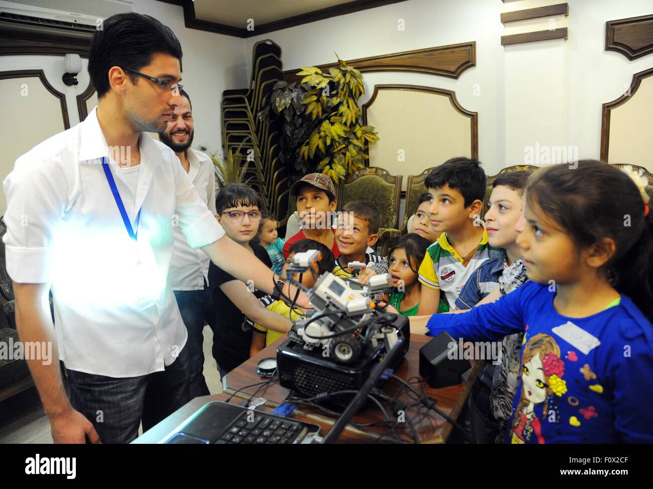 Damasco, Siria. Il 22 agosto, 2015. Siro orfani a frequentare un corso di formazione sulla progettazione di semplici progetti elettronici in un campo estivo in Damasco Capitale della Siria, su agosto 22, 2015. Il corso è stato tenuto dal governo siriano in cooperazione con le associazioni di beneficenza locali per aiutare a sviluppare le competenze dei bambini che hanno perso i loro genitori durante il conflitto in Siria. © Ammar/Xinhua/Alamy Live News Foto Stock