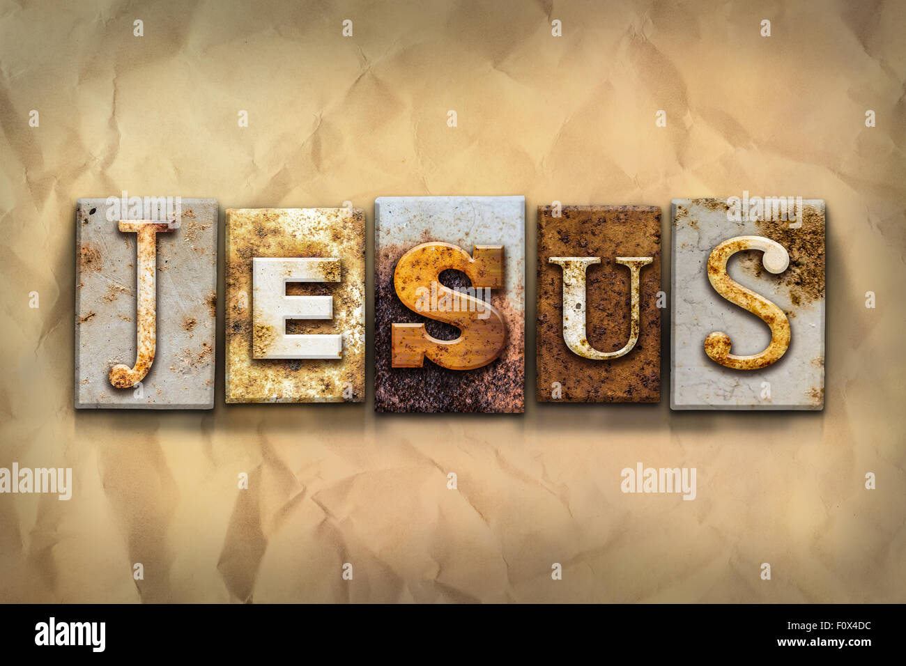 Il nome "Gesù" scritta in metallo arrugginito rilievografia tipo su una sbriciolato invecchiato lo sfondo della carta. Foto Stock