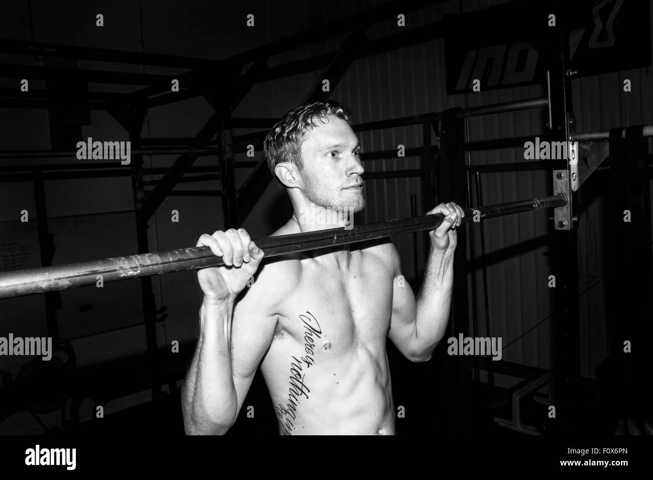 Crossfit atleta facendo pull-up Foto Stock