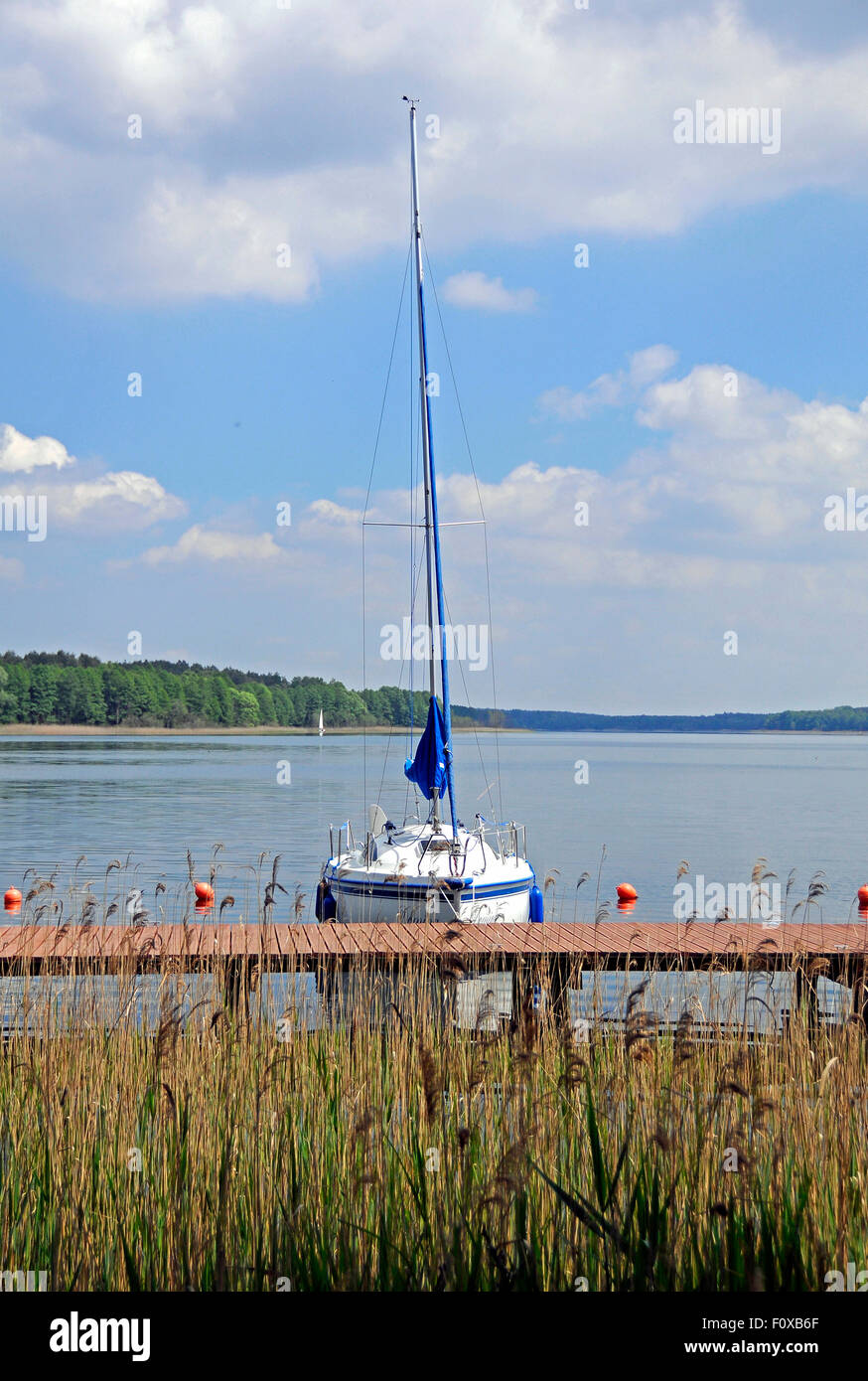 Barca a vela ormeggiata nel piccolo porticciolo sul lago Powidz, Polonia Foto Stock