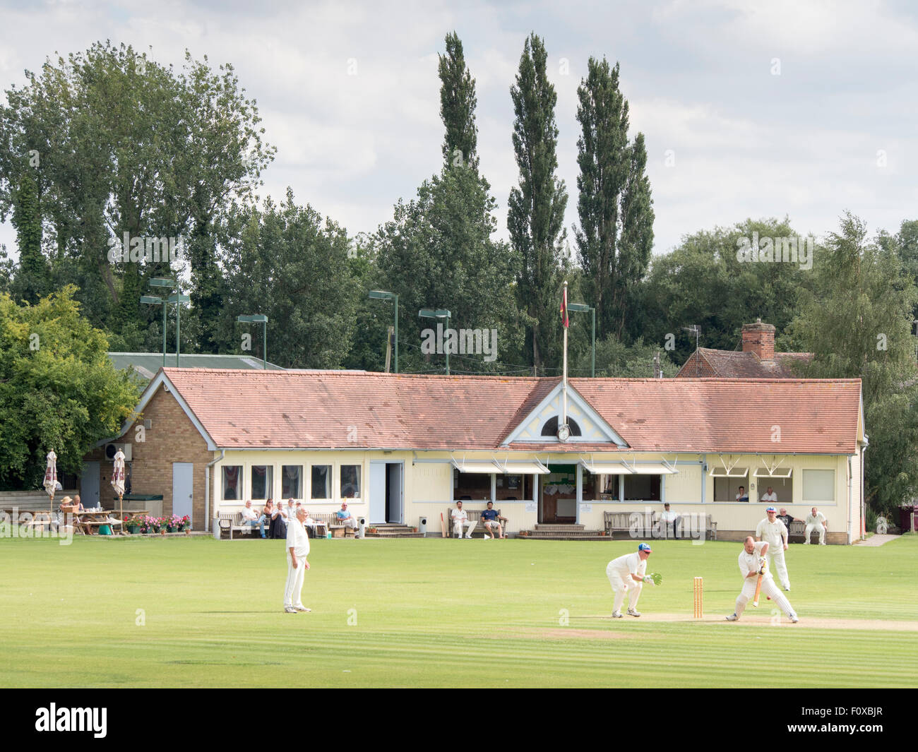 Sudbury Cricket Club: i giocatori e spettatori godetevi una partita di cricket in un pomeriggio d'estate. Foto Stock