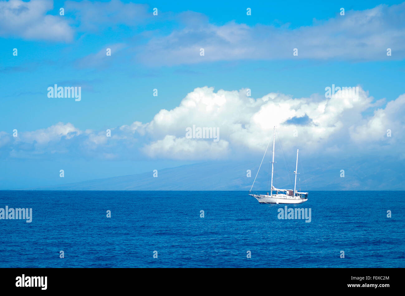 Barca a vela al largo della costa di Maui, Hawaii, con lanai in background. Cielo blu, blu acqua, barca a vela bianca, STATI UNITI D'AMERICA Foto Stock