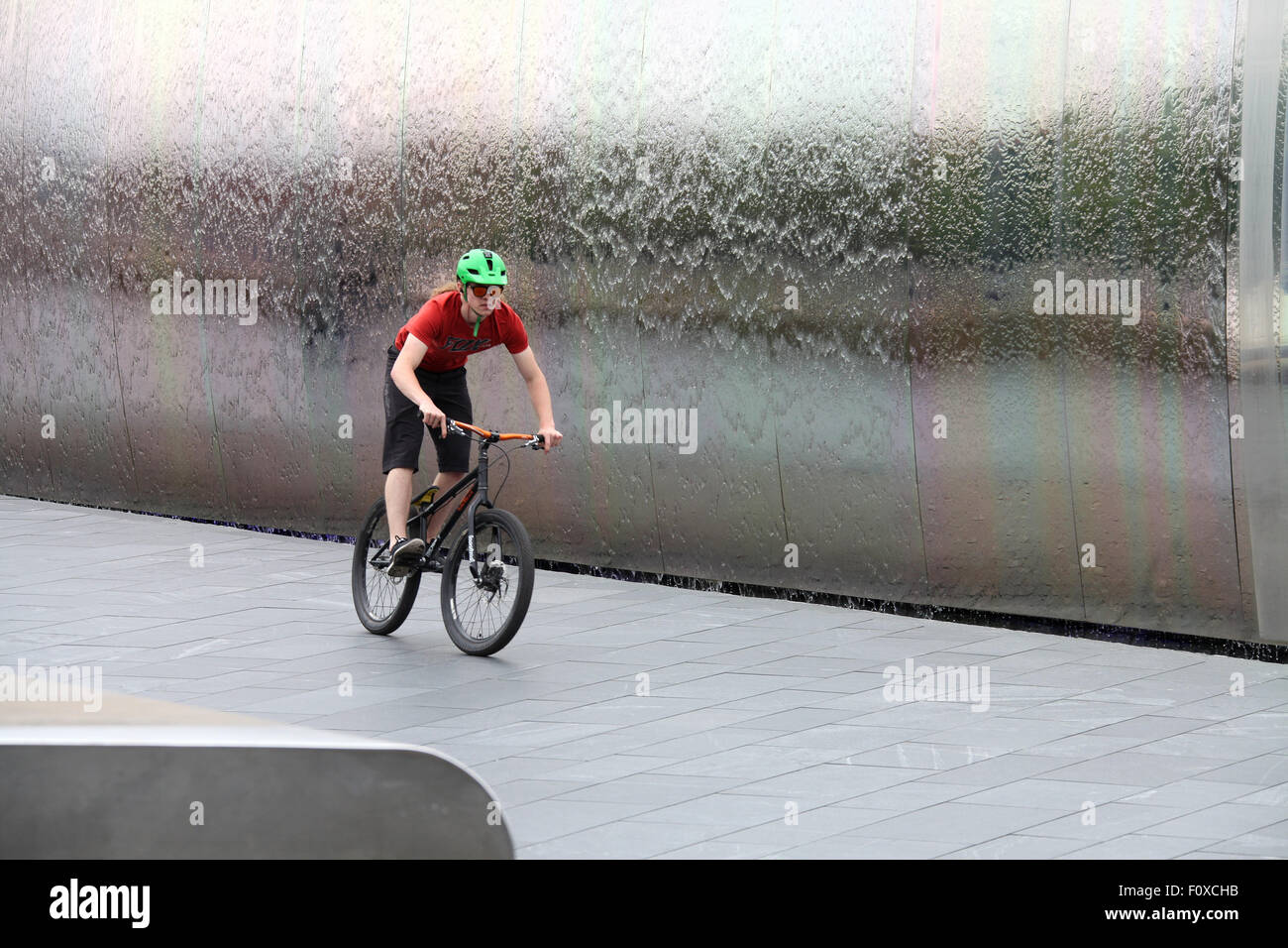 Stunt ciclista nella parte anteriore del bordo di taglio scultura in acciaio a Sheffield stazione ferroviaria Foto Stock