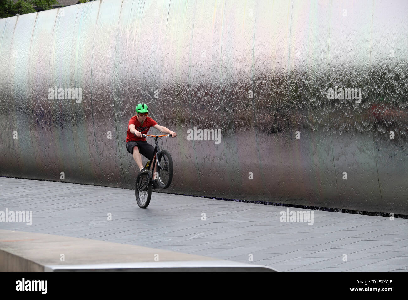 Stunt ciclista nella parte anteriore del bordo di taglio scultura in acciaio a Sheffield stazione ferroviaria Foto Stock