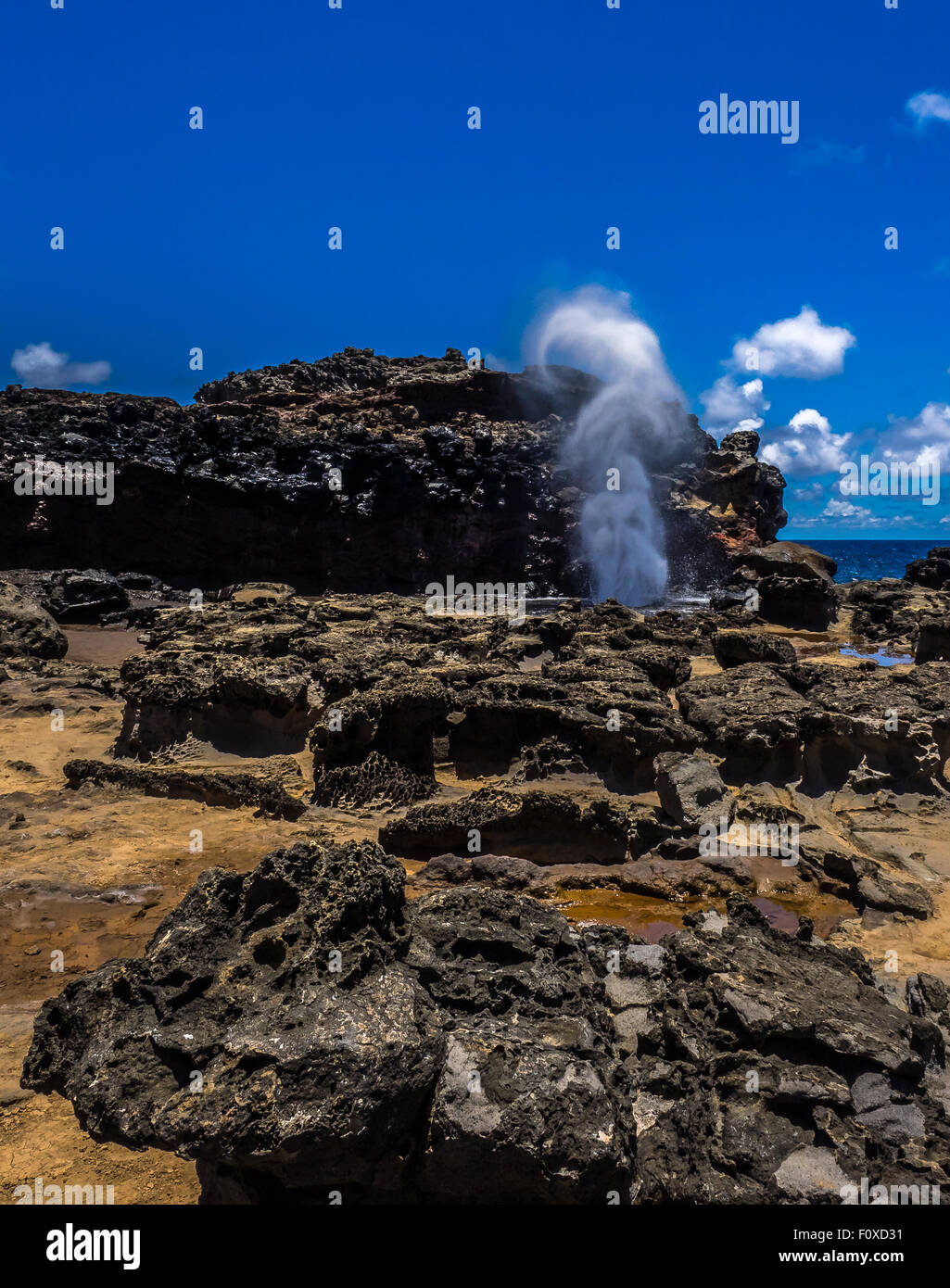 Nakalele Blowhole Pohelua Bay Maui con pietra lavica formazioni in primo piano e il cielo limpido sopra. Foto Stock