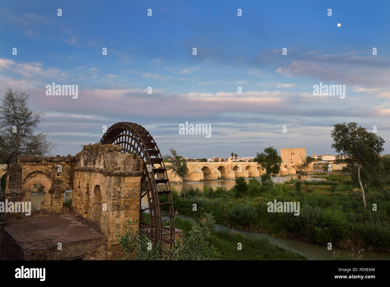 Luna al tramonto oltre il Fiume Guadalquivir con Albolafia Waterwheel ponte romano e la Torre di Calahorra Cordoba Foto Stock