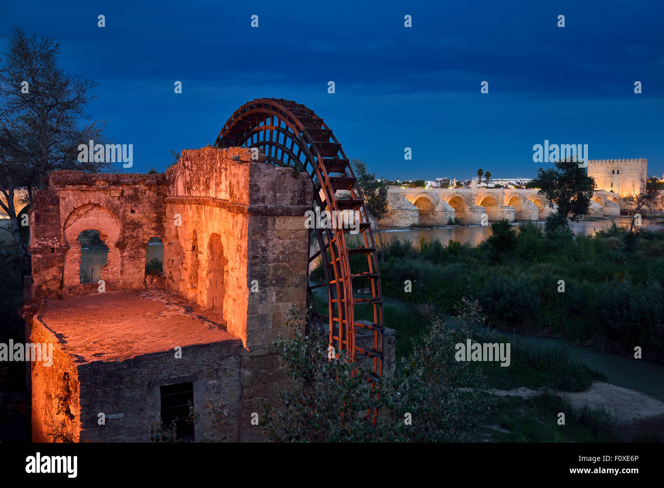 Luci su Albolafia Waterwheel al tramonto sul fiume Guadalquivir con ponte romano e la Torre di Calahorra Cordoba Foto Stock