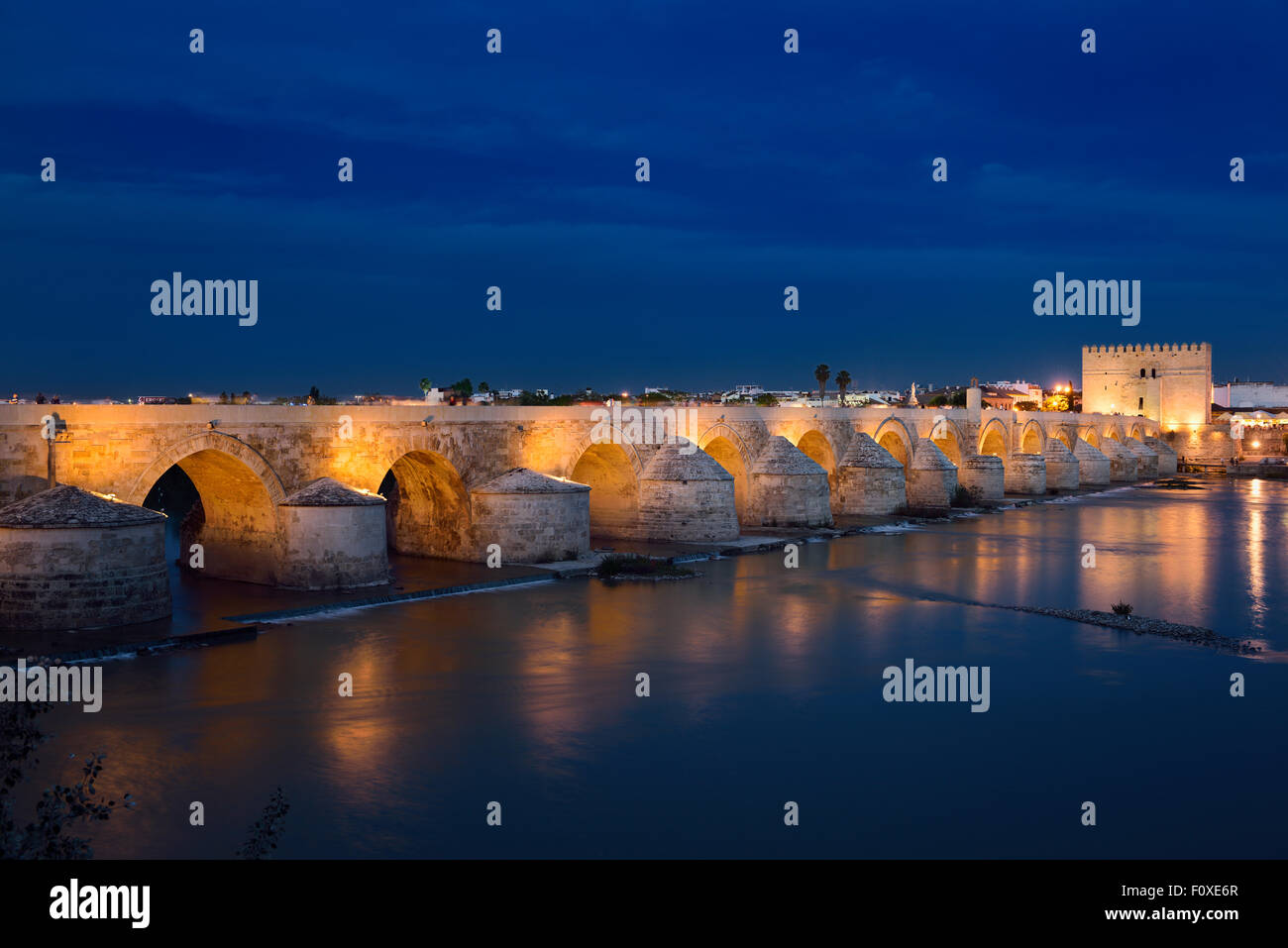 Luci riflesse nel fiume Guadalquivir dal ponte romano e la Torre di Calahorra al crepuscolo Cordoba Foto Stock