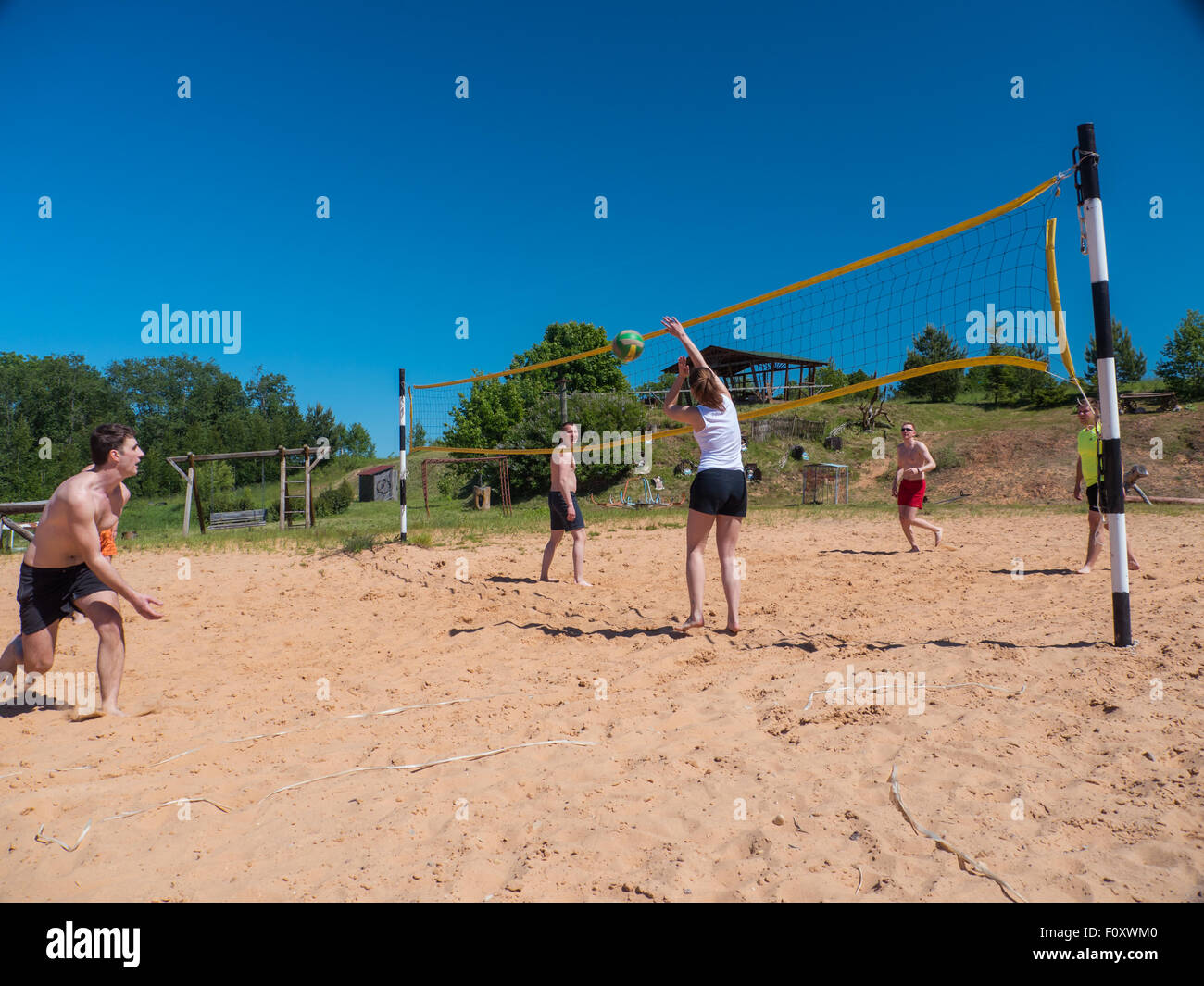 Un gruppo di ragazzi giocare pallavolo in spiaggia Foto Stock