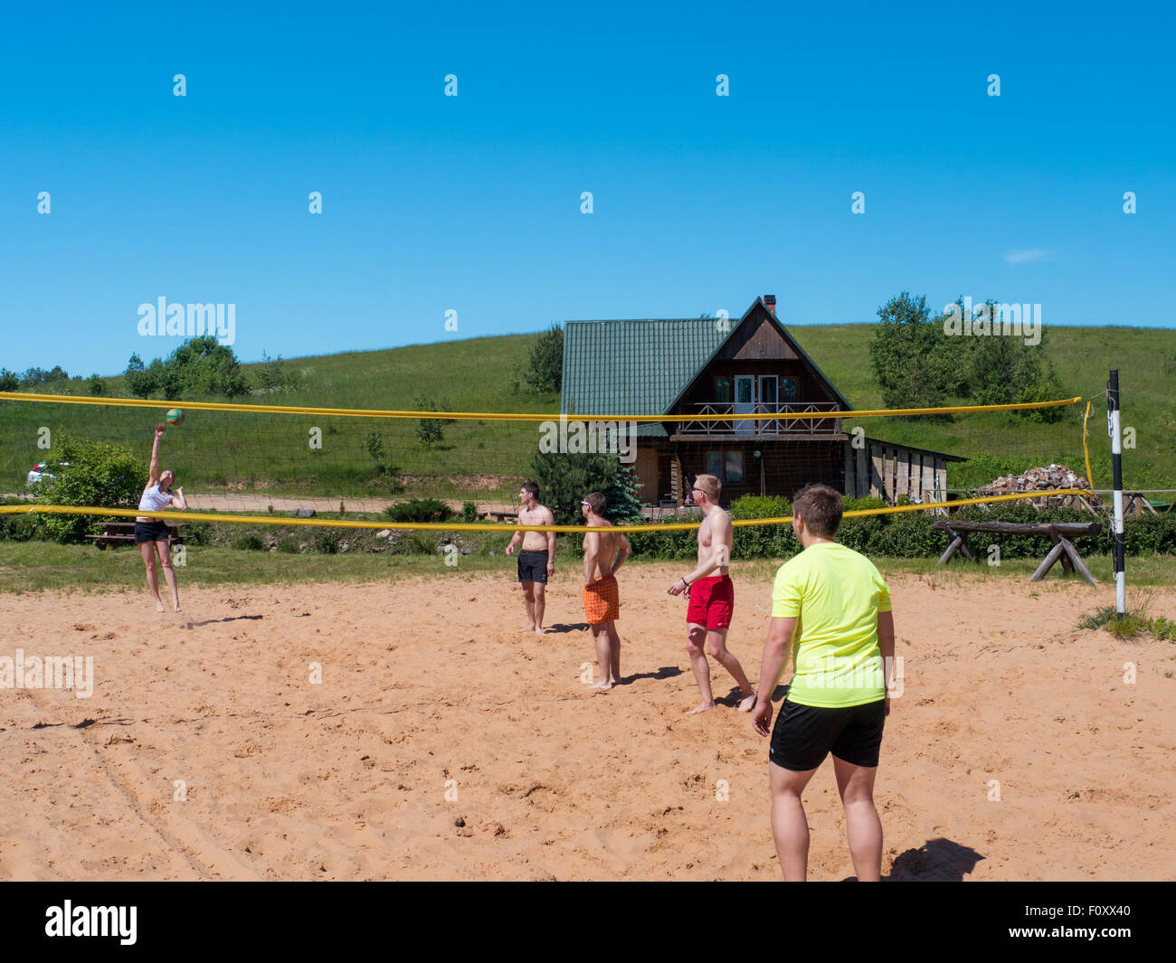 Un gruppo di ragazzi giocare pallavolo in spiaggia Foto Stock