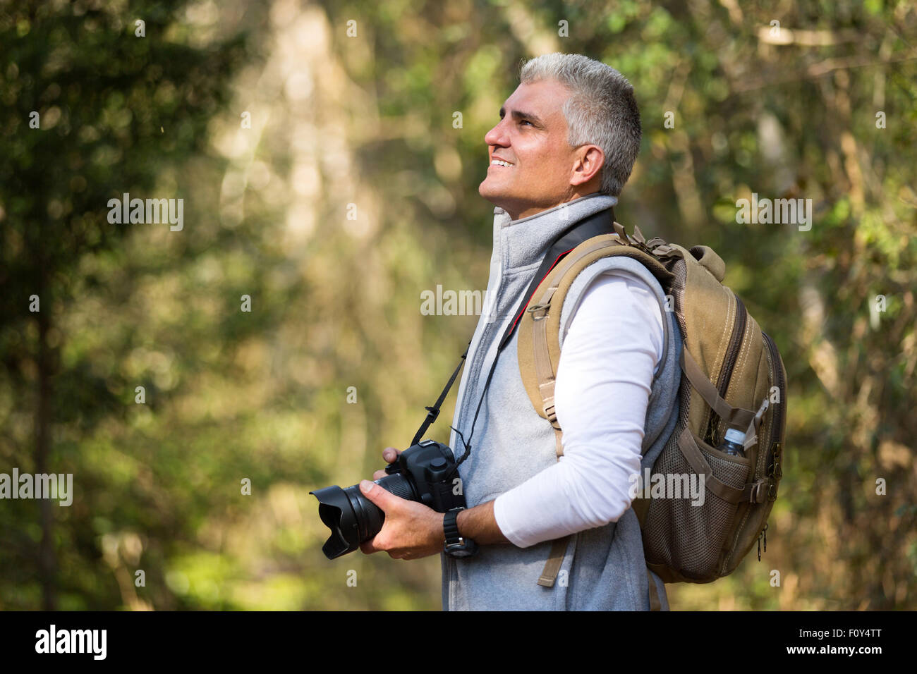 Uomo bello escursioni in montagna con la fotocamera reflex digitale Foto Stock