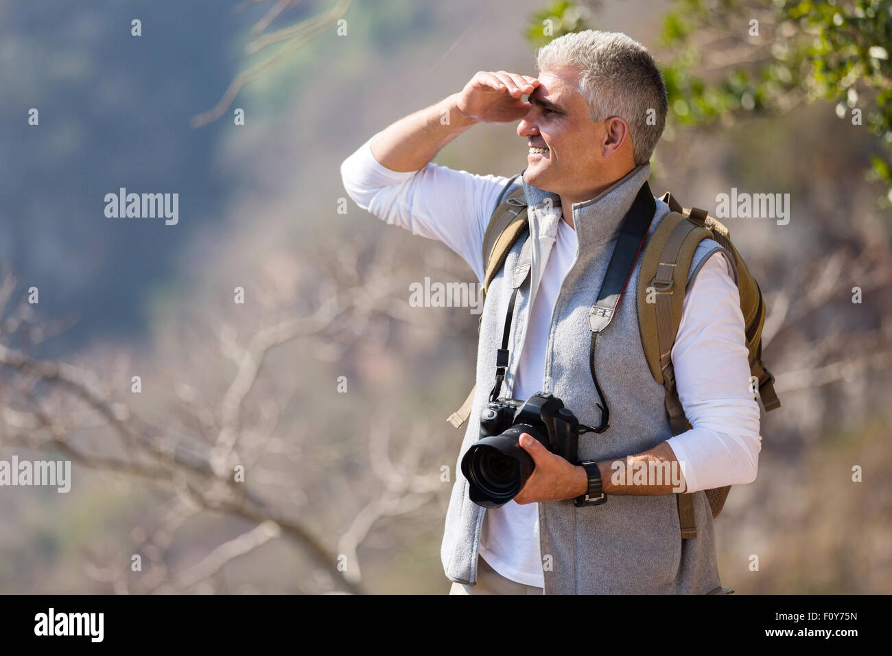 Uomo maturo escursioni in montagna con la fotocamera reflex digitale Foto Stock