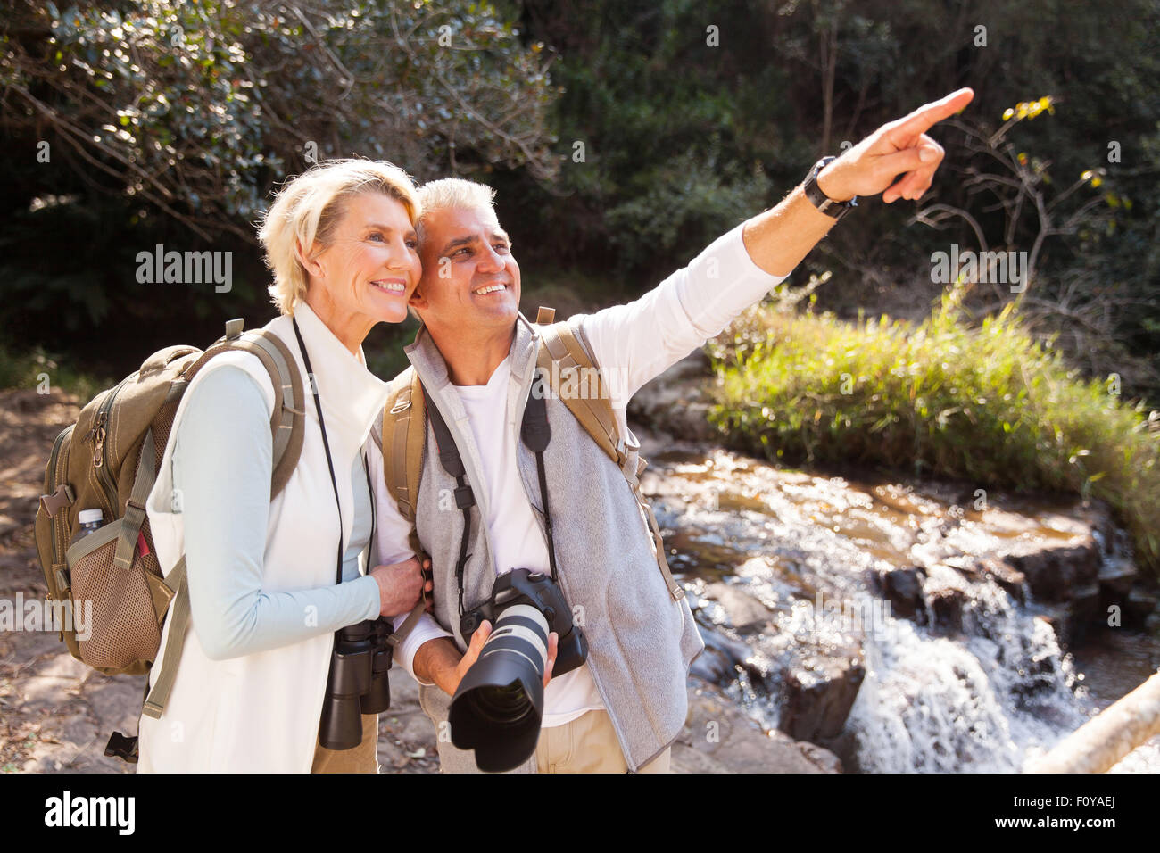 Allegro coppia senior escursionisti rivolto nella valle di montagna Foto Stock