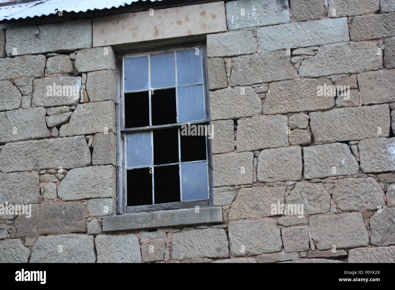 Edificio di pietra arenaria con finestra assenti diversi pannelli di vetro Foto Stock