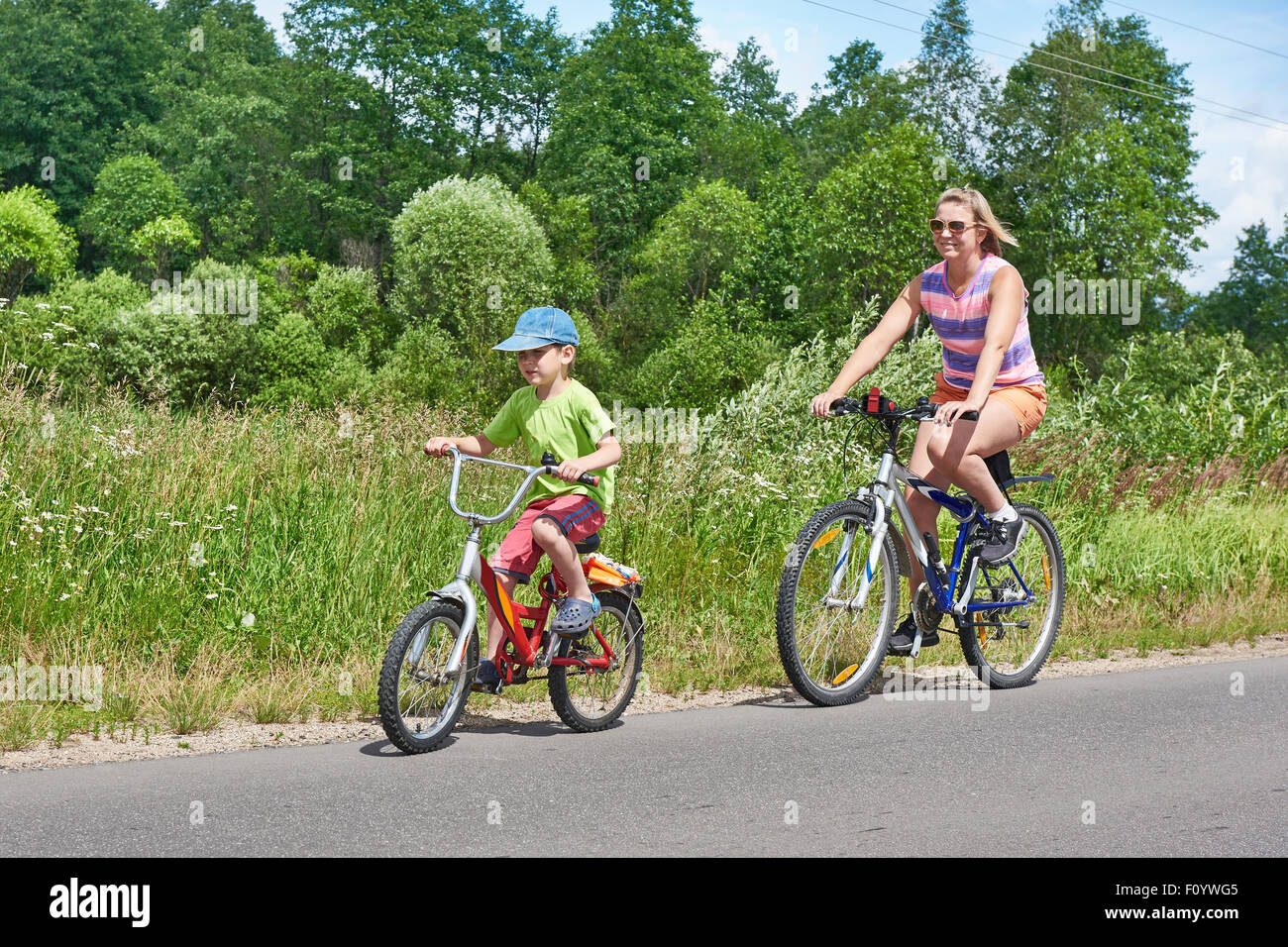 Felice madre e figlio su una corsa in bicicletta sulla strada di un paese Foto Stock