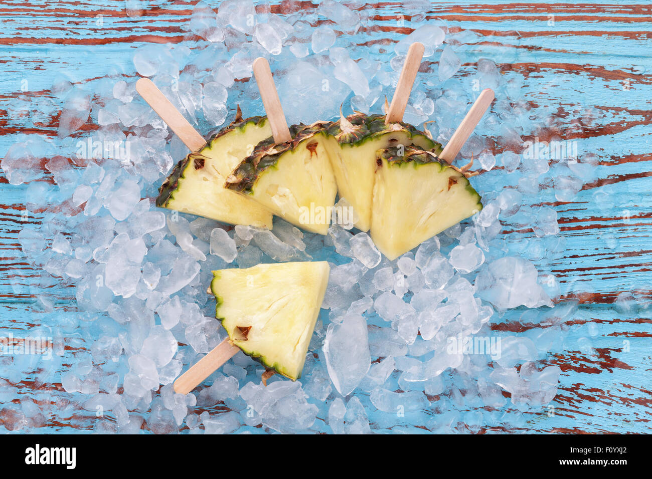 Ananas ghiaccioli yummy Frutta estiva fresca dessert su vintage vecchio legno teak blu Foto Stock