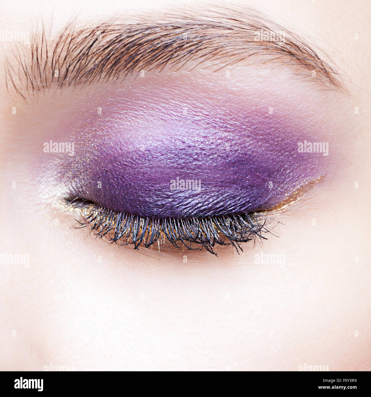 Closeup colpo di donna chiuso occhio e sopracciglia con violetta palpebra giorno trucco Foto Stock
