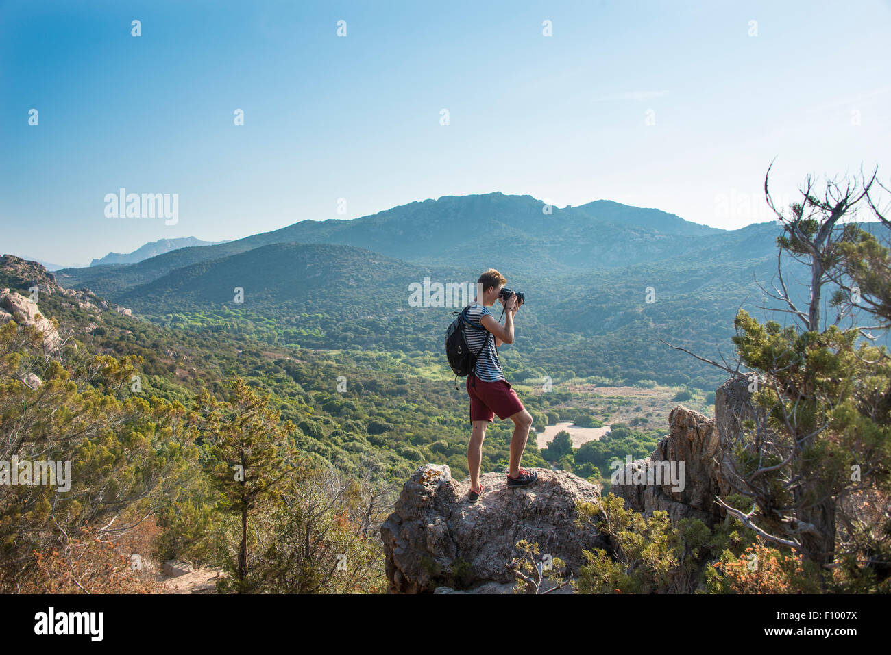 Giovane uomo facendo fotografia di paesaggi di montagna viste in Sartène, Corsica, Francia Foto Stock
