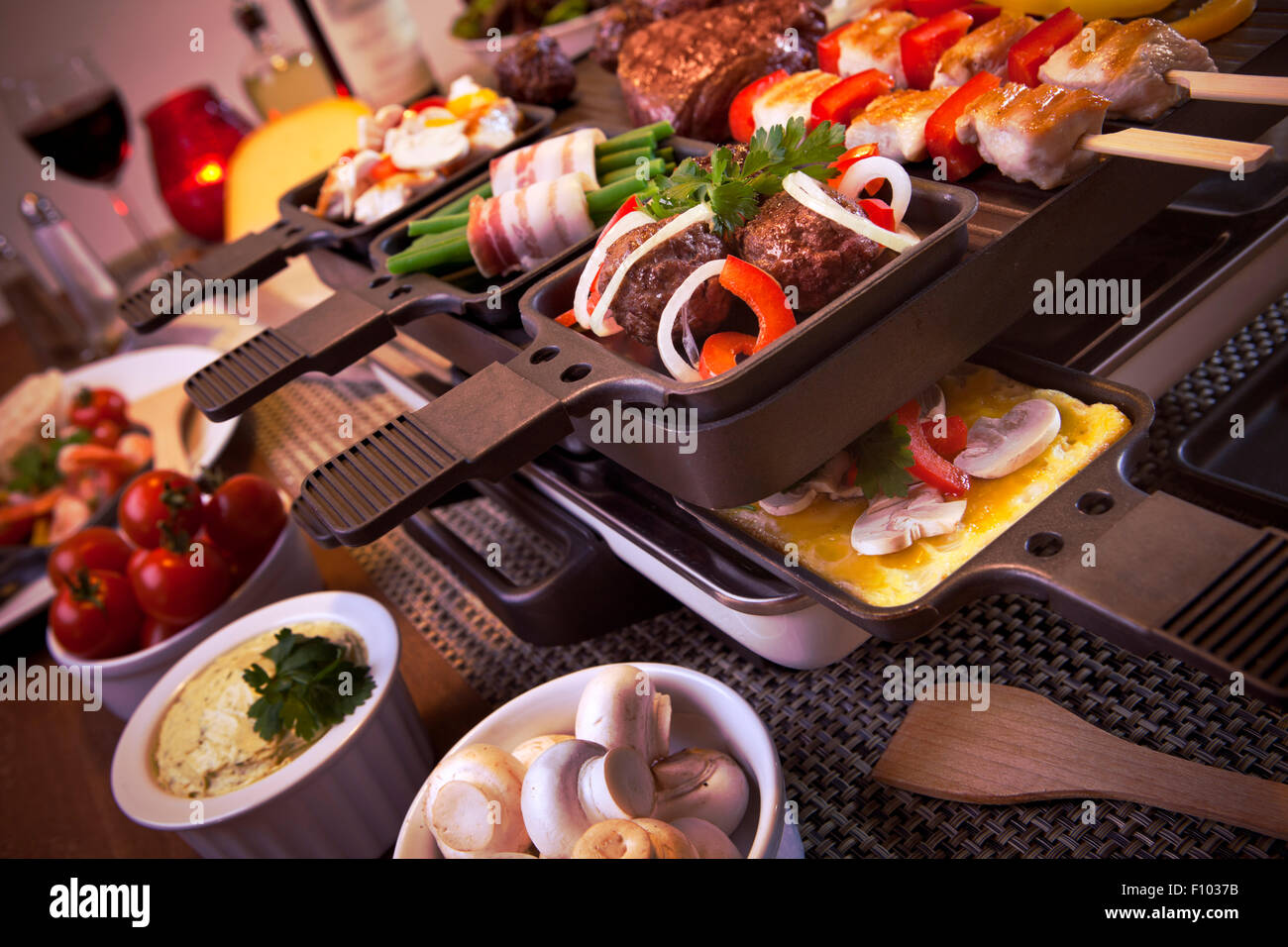 La raclette svizzera o la variante olandese "gourmetten'. Una tabella riempita con gli ingredienti per un piatto che di solito è servito sul celebrato Foto Stock