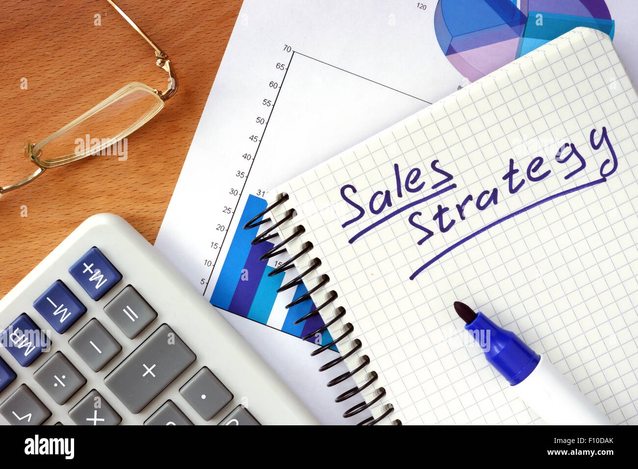 Blocco note con la strategia di vendita concetto su un pannello di legno. Foto Stock