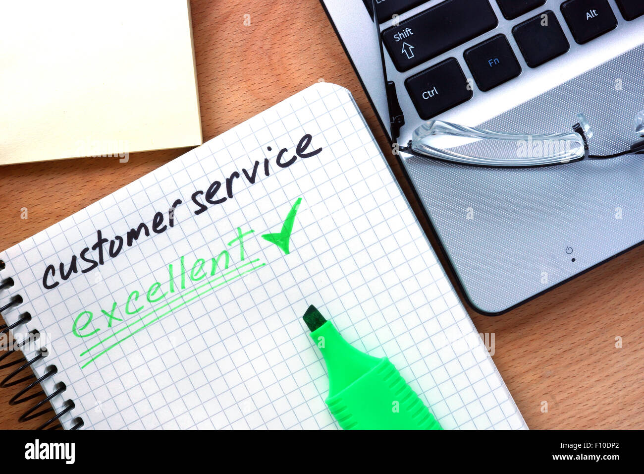 Blocco note con parole servizio clienti su un sfondo di legno Foto Stock