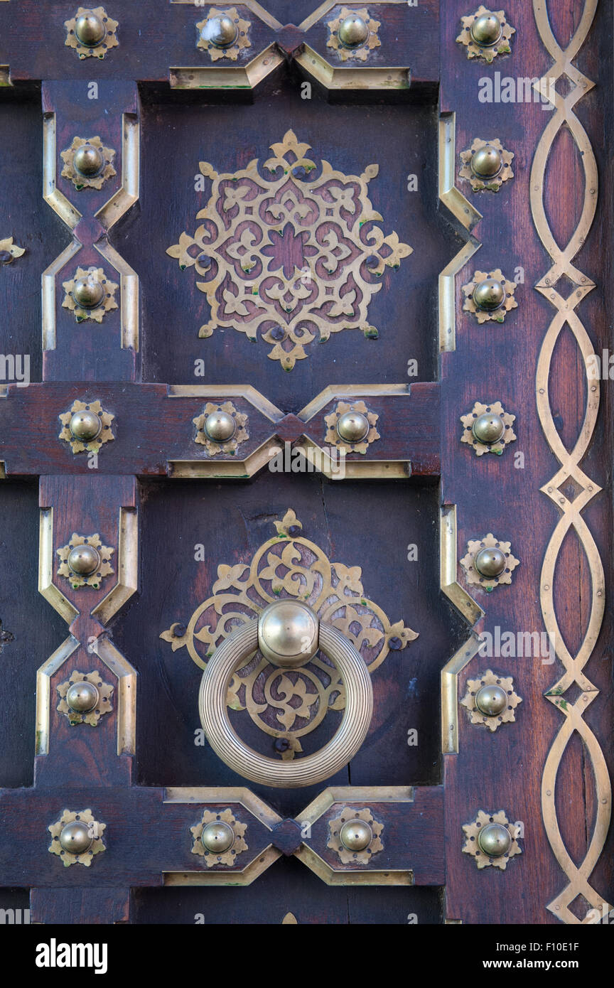 Jaipur, India. Porta con pannelli con perni in ottone e le decorazioni e un grande anello maniglia; City Palace Foto Stock