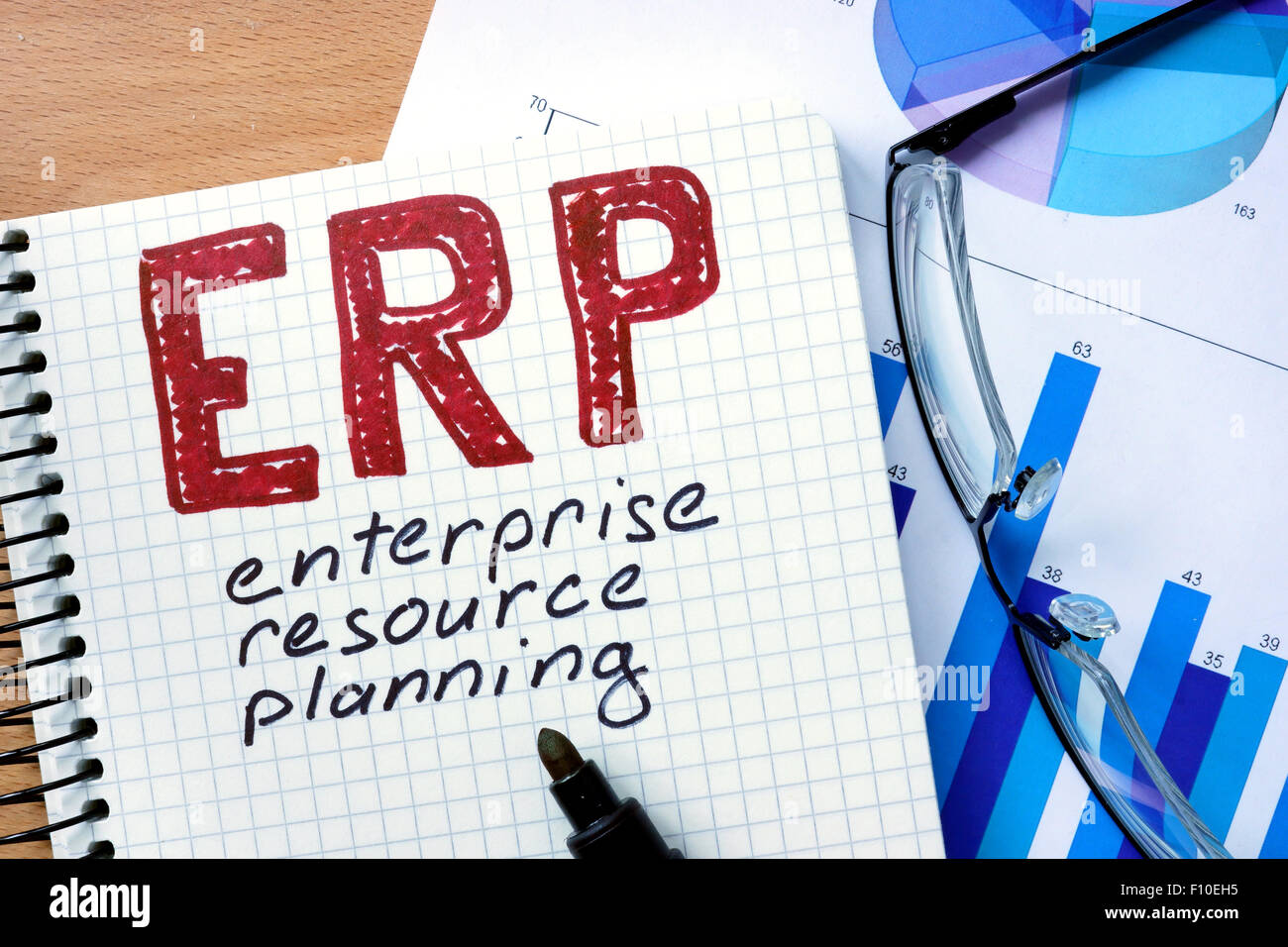 Blocco note con le applicazioni di Enterprise Resource Planning (ERP) ufficio su un tavolo di legno. Foto Stock