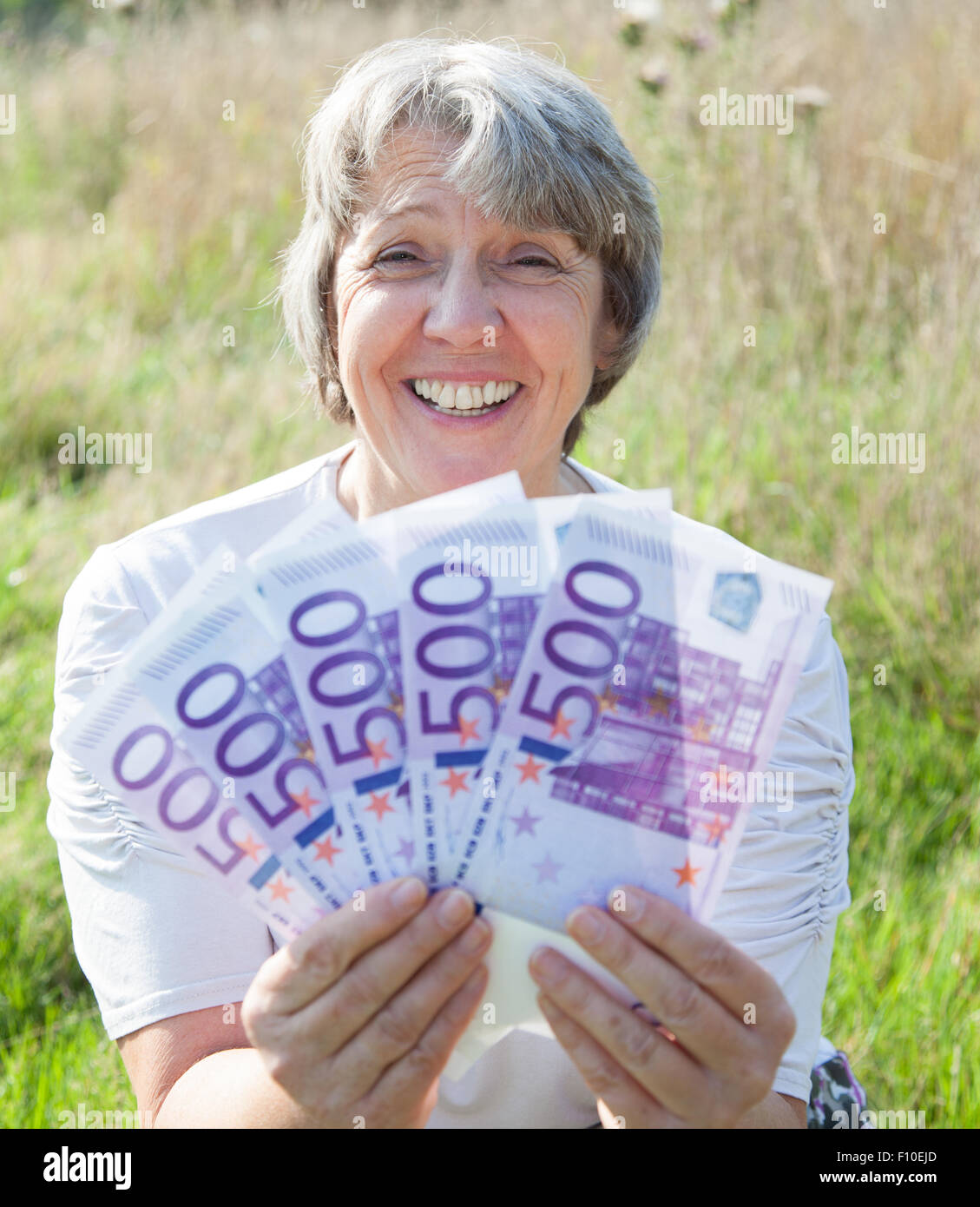 La vecchiaia donna azienda 2500 euro Foto Stock