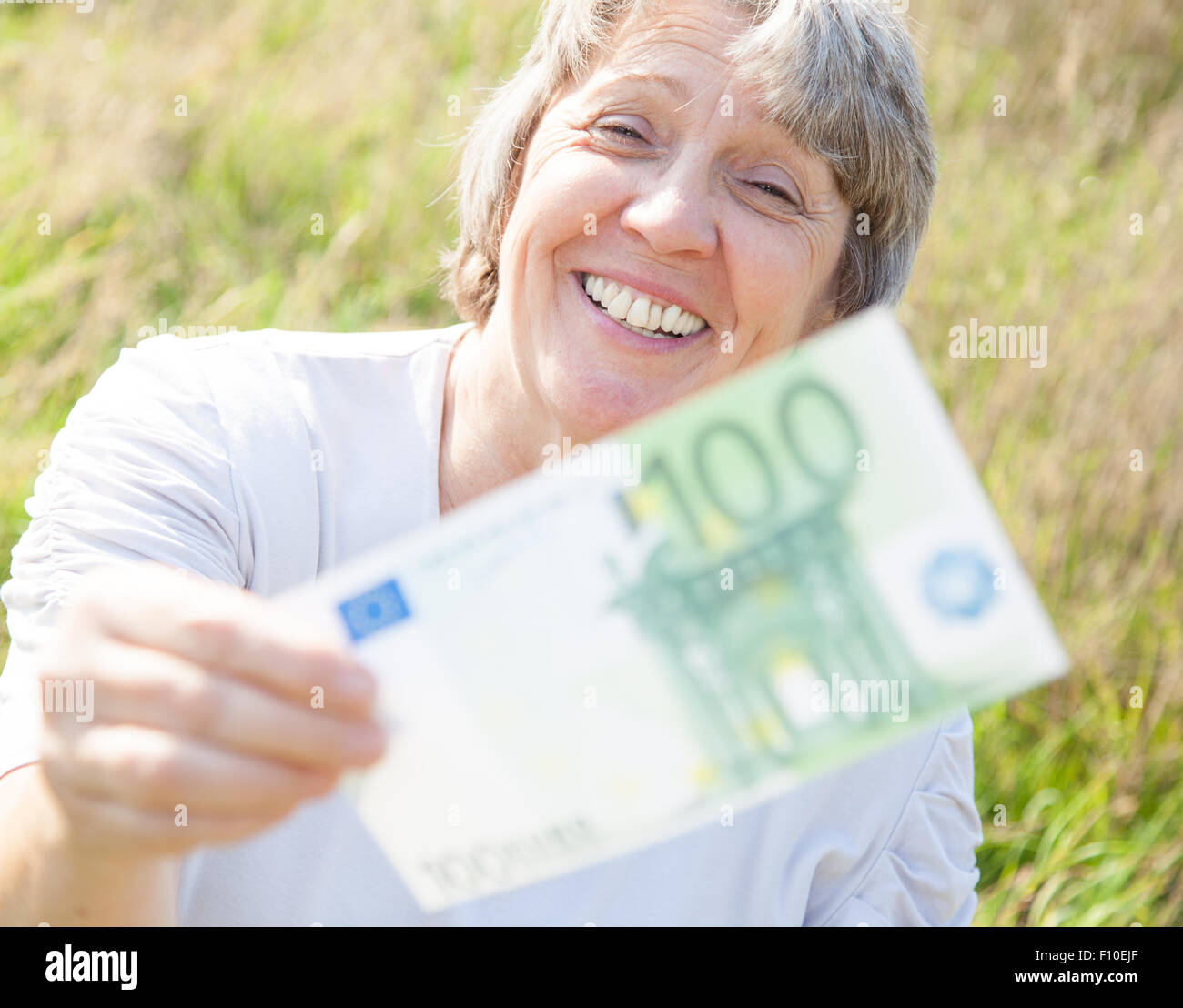 Età della donna con le mani su centinaia di euro Foto Stock