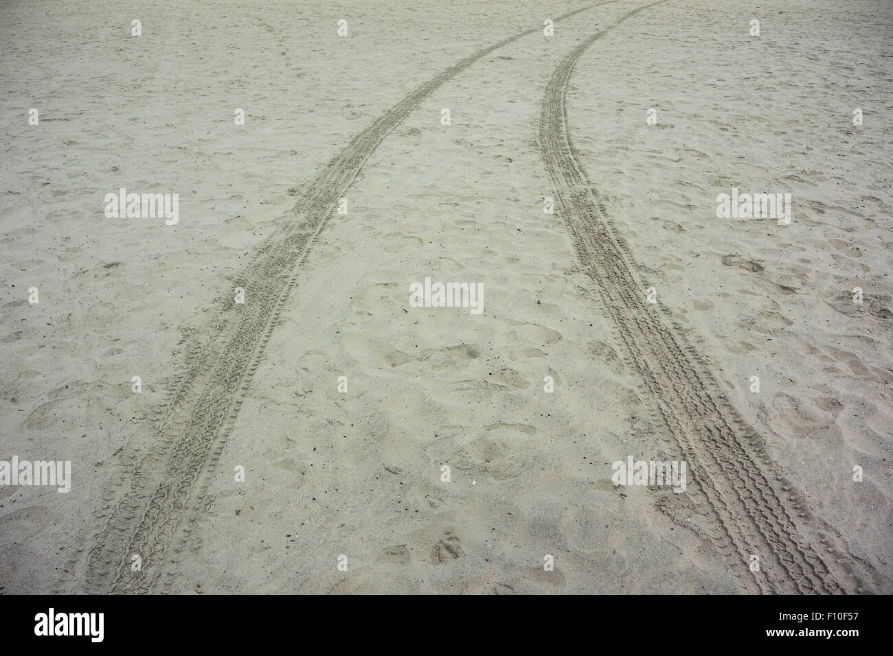 Tracce di pneumatici piegare in una curva di sabbia su una spiaggia deserta Foto Stock