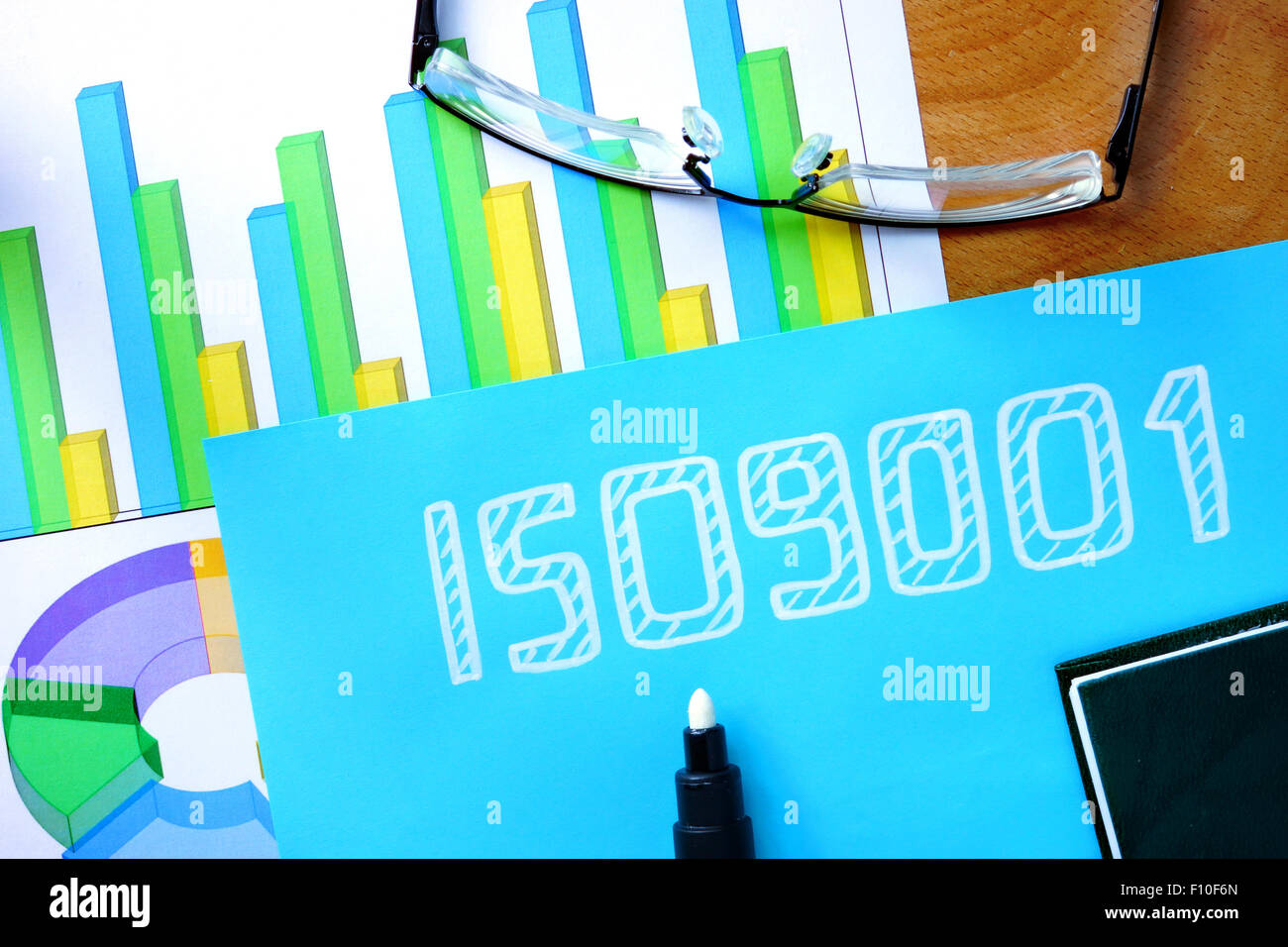 Carta blu con word iso 9001 e bicchieri. Foto Stock