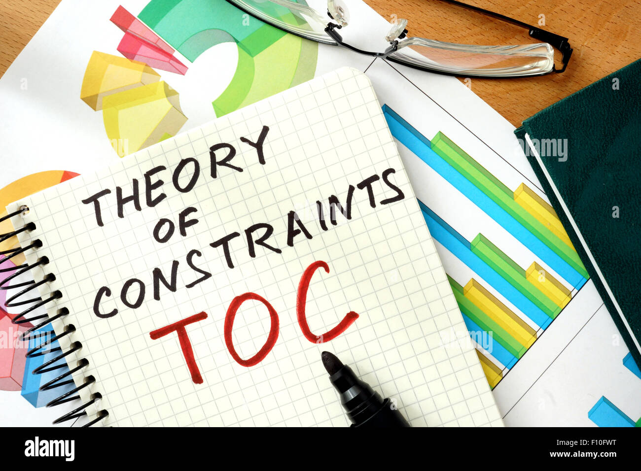 Parole Sulla Teoria dei Vincoli TOC sul blocco note e grafici. Foto Stock