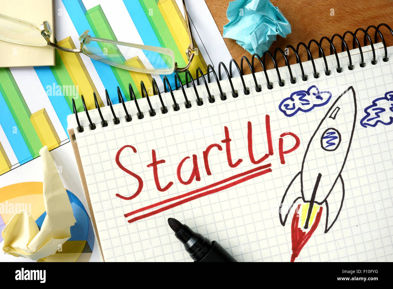 StartUp parola scritta sul blocco note e grafico. Foto Stock