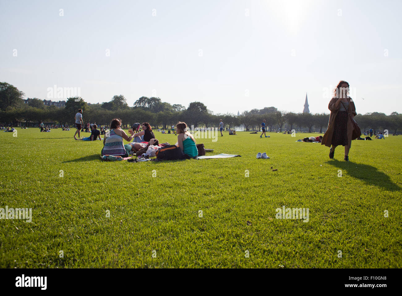 Edimburgo, Scozia, Regno Unito. 23 Agosto, 2015.persone in appoggio nei prati Park durante veramente calda e soleggiata giornata in Edinburgh - la temperatura è 23 °C. Il Fringe Festival ha reso la città crawded e pieno di atmosfera artistica. Un sacco di persone in formazione sono le abilità circensi e fare barbecue, godersi il sole. Credito: Joanna Tkaczuk/Alamy Live News Foto Stock