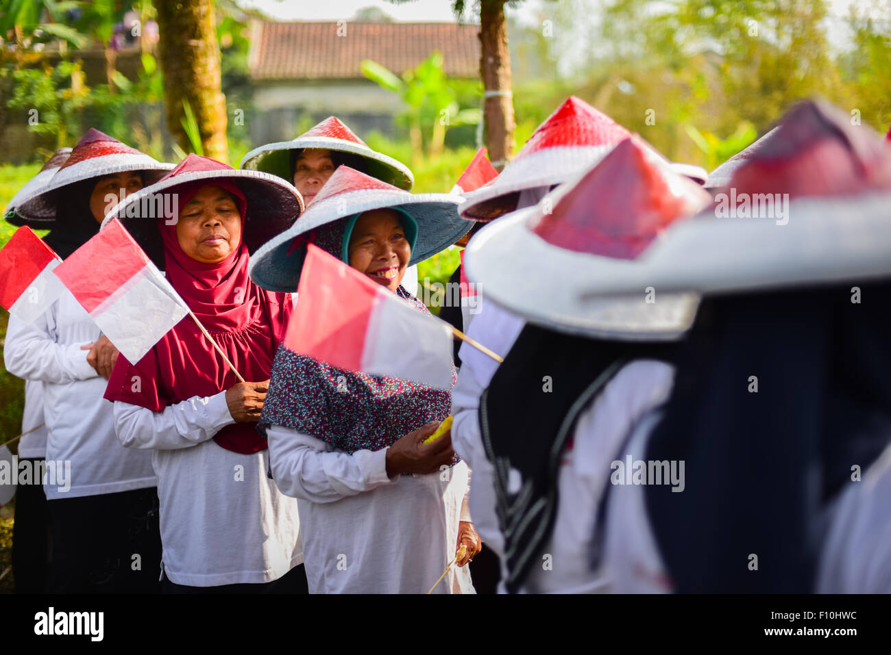 Donne contadine che hanno portato piccole bandiere indonesiane nel giorno dell'indipendenza; fotografate durante il Festival Sarongge 2015. Foto Stock