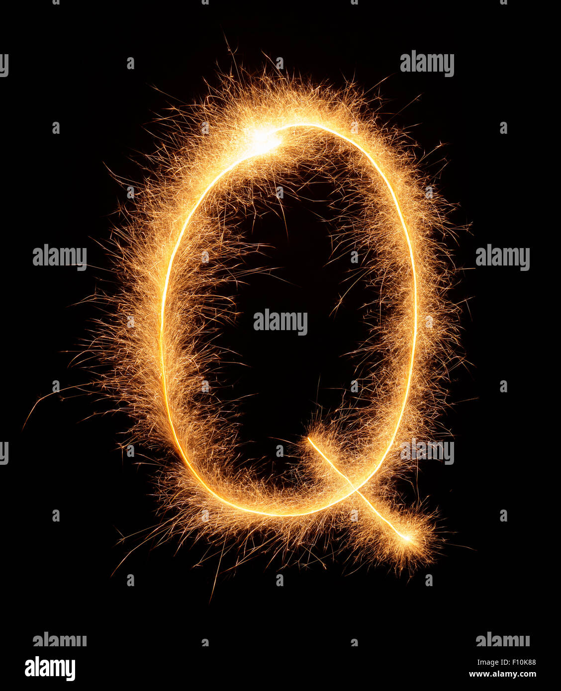 " Q " lettera estratta con brillantini bengali isolati su sfondo nero Foto Stock