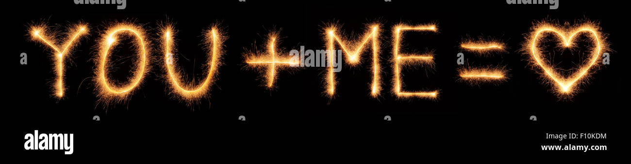 "You + ME = cuore' lettering disegnato con brillantini bengali isolati su sfondo nero Foto Stock