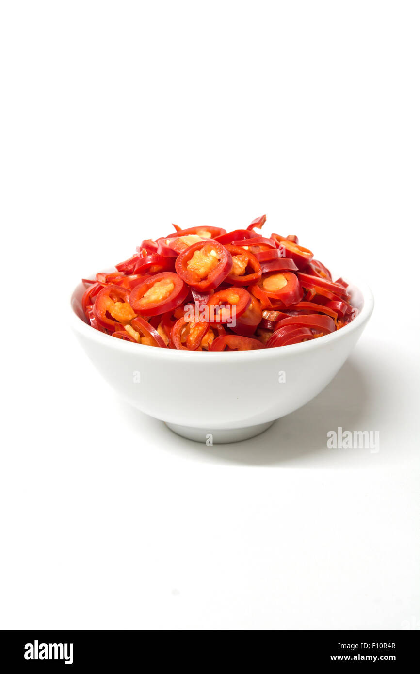 Bruciare i grassi mangiando hot chili, fette di peperoncino rosso in bianco vaso in ceramica Foto Stock