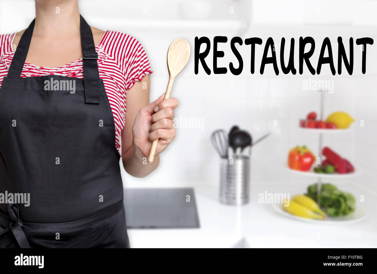 Ristorante cuocere tenendo il cucchiaio di legno dello sfondo. Foto Stock