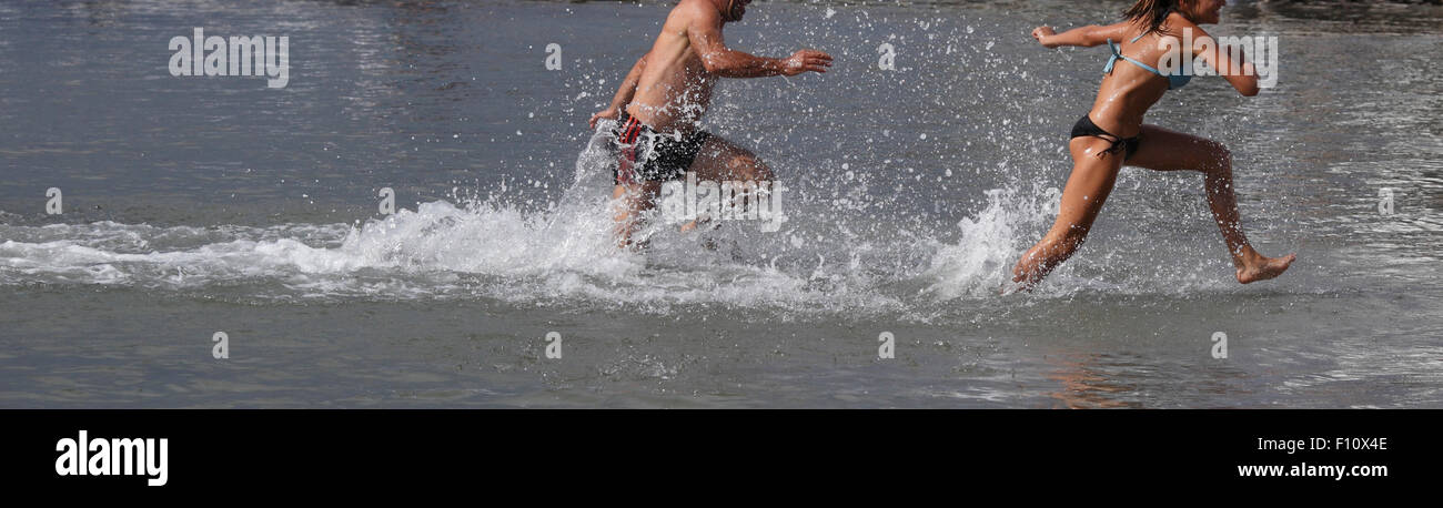 Due popoli gambe in esecuzione attraverso le onde Foto Stock