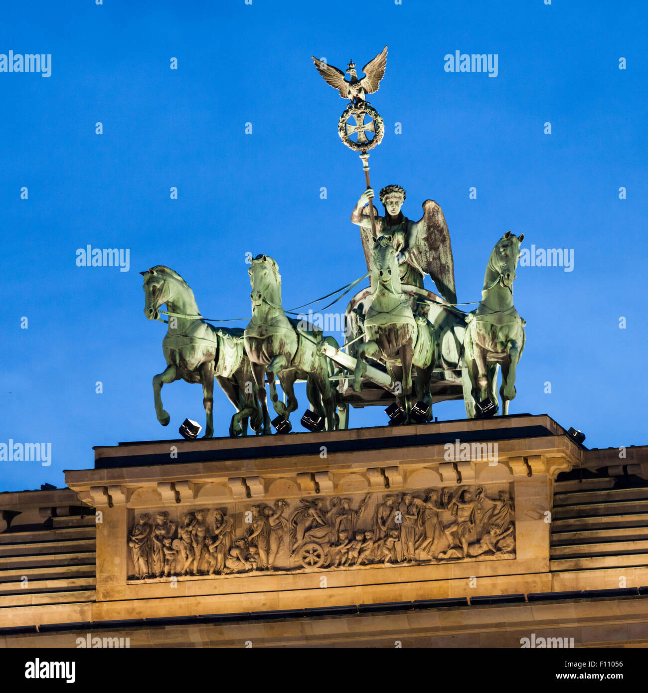 Vista notturna della quadriga di bronzo dorato (carro trainato da quattro cavalli) sulla sommità della porta di Brandeburgo a Pariser Platz, Berlin, Germania Foto Stock